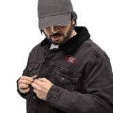 Black denim sherpa jacket with eco-friendly wool lining, featuring a red embroidered logo on the chest. Modeled with button closure.